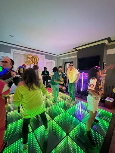 Birthday guests celebrating on a green LED floor
