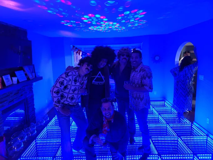 Friends posing together on a blue illuminated dance floor