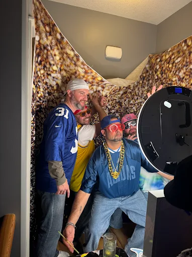 Party guests posing in front of a photo booth camera